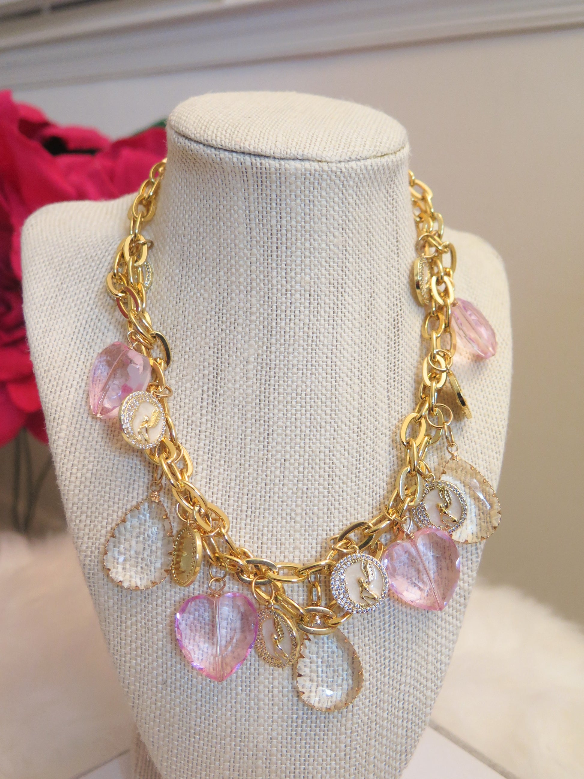 pink heart-shape charms on  gold necklace