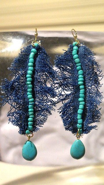 A pair of denim earrings with turquoise beads and a leaf design.