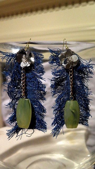 A pair of denim earrings with green beads and silver flower detail