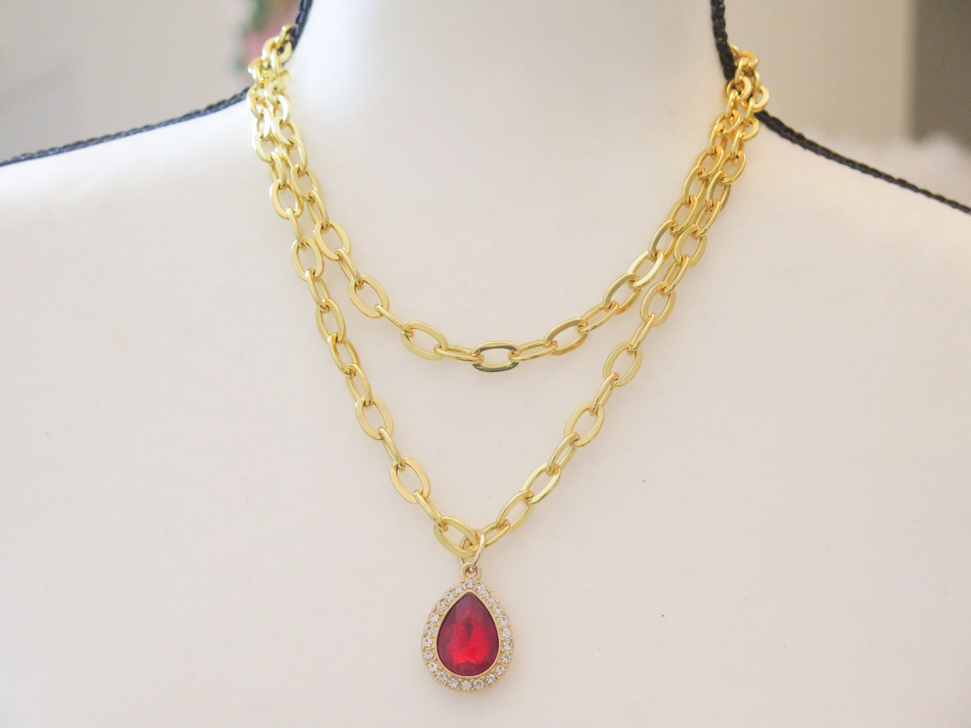 double gold necklace with red sparkling pendant