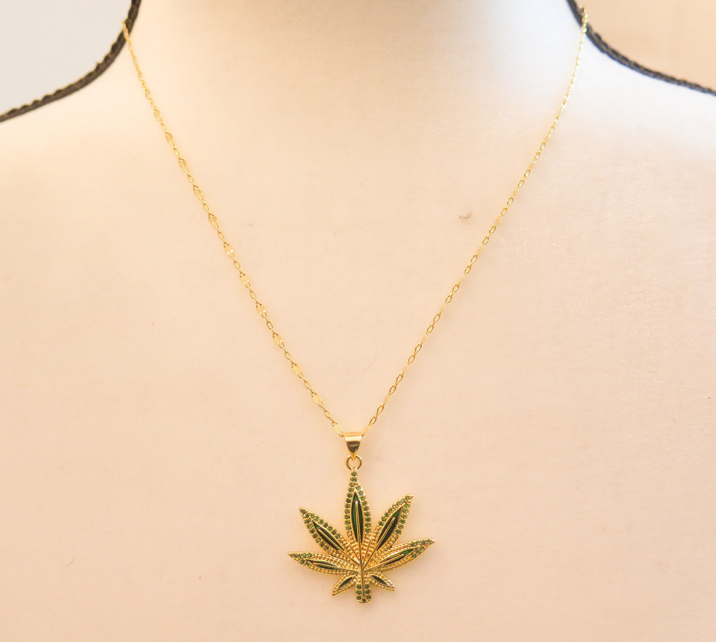 Gold necklace with green sparkling leaf necklace