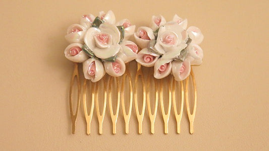 A gold porcelain hair comb featuring a floral design with rose patterns, gold plated wires and a gold plated comb.