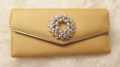 A yellow wallet with a rhinestone embellishment in the center.