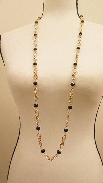 long gold necklace with black beads